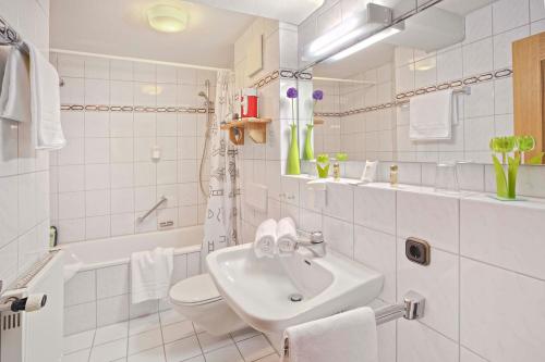 a white bathroom with a sink and a toilet at Berg- und Aktivhotel Edelsberg GmbH in Bad Hindelang