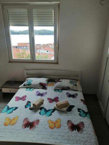a bedroom with a bed with butterflies on it at Studio apartman Laca in Šibenik