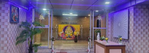 a purple room with a altar and a painting on the wall at N S CHITHRA MAHAL in Tiruvannāmalai