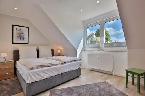 a bedroom with a bed and a large window at Haus am Seehof 9 Ferienwohnung Ostseeliebe Nr 5 in Sierksdorf
