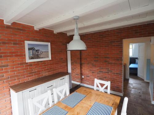 a kitchen with a brick wall and a wooden table at Pod Morskim Niebem in Poddąbie