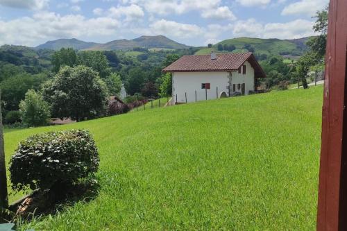 a house on a hill with a green field at Cambo les Bains Piscine Vue Montagnes in Souraïde