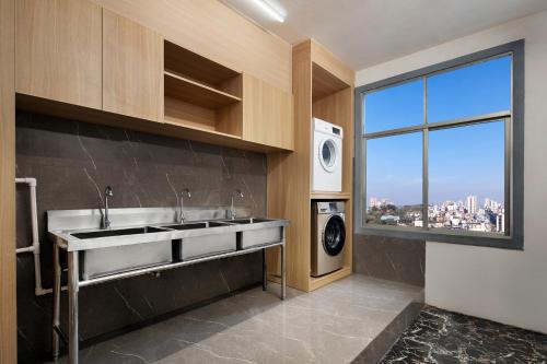 a kitchen with a sink and a washing machine at Unitour Hotel, Xiangxiang Dongfeng Square in Xiangxiang