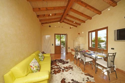 un soggiorno con divano giallo e tavolo di Villa Fior di Loto a Limone sul Garda