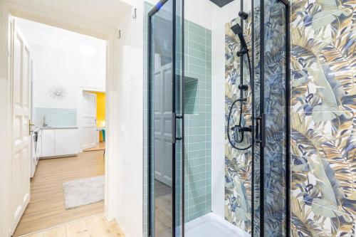 a bathroom with a shower with green tiles at Cityscape Apartments Theresa in Budapest
