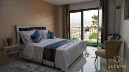 a bedroom with a large bed and a large window at Bella Address Hotel Beach in Saidia 