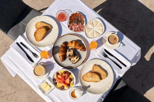 - une table blanche avec des assiettes de nourriture pour le petit-déjeuner dans l'établissement LA CASA DEL PANTANO, à La Vall de Laguar