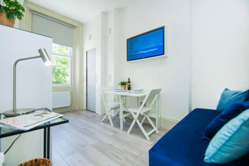 Una sala de estar con un sofá azul y una mesa. en SoBo Studio 2 - by Brighton Holiday Lets, en Brighton & Hove