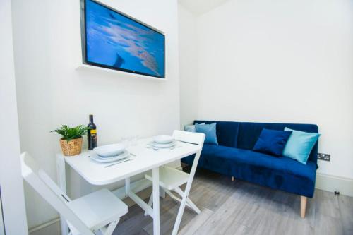 sala de estar con mesa blanca y sofá azul en SoBo Studio 2 - by Brighton Holiday Lets, en Brighton & Hove