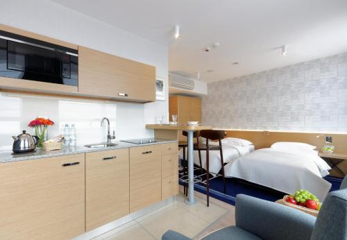 a kitchen and a bedroom with a bed in a room at Hotel Marina Club Old Town View in Gdańsk