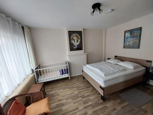 1 dormitorio con cama y cuna en Repos St Elisabeth nabij Plopsaland, en De Panne