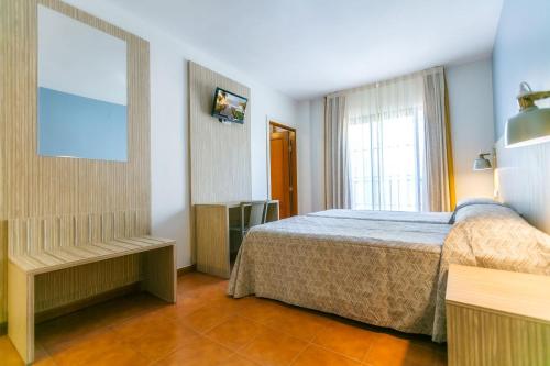 1 dormitorio con cama y ventana en Hotel Galicia, en Fuengirola