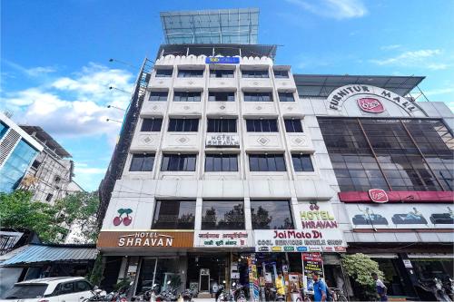 a tall white building on a busy city street at FabHotel Shravan in Nagpur