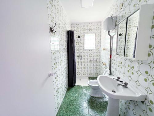a white bathroom with a sink and a toilet at Villa Paz in Villanueva de Castellón