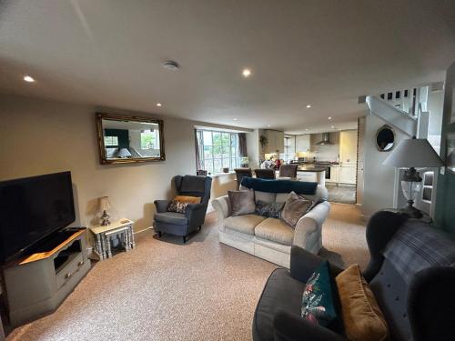 a living room with a couch and a tv at Tanyard Cottage - Whixley, York, North Yorkshire in York