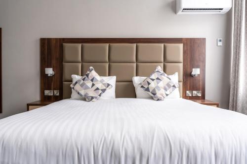 a bedroom with a large white bed with pillows at Trafford Hall Hotel Manchester, Trademark Collection by Wyndham in Manchester