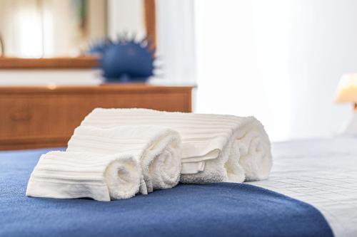 una pila di asciugamani seduta su un letto di Vieira Casino ad Armação de Pêra