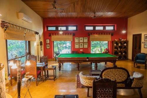 una mesa de billar en una habitación con paredes rojas en Tree of Life Resort Dehradun Foothills en Dehradun