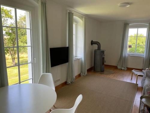 ein Wohnzimmer mit einem Tisch und einem Kamin in der Unterkunft Landidylle auf dem Rittergut in Blomberg