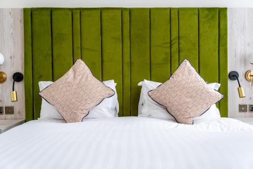 a white bed with two pillows on top of it at Trafford Hall Hotel Manchester, Trademark Collection by Wyndham in Manchester