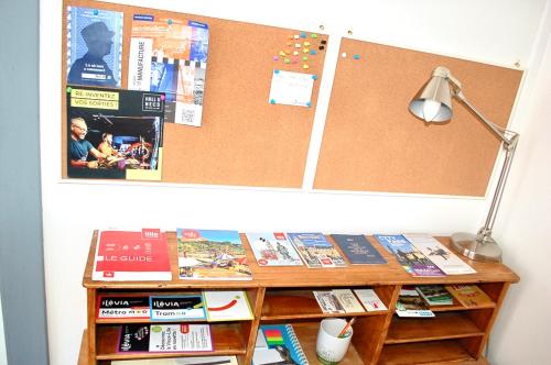 un bureau avec des livres et une lampe sur un mur dans l'établissement Cocon avec cour citadelle Vauban, à Lille