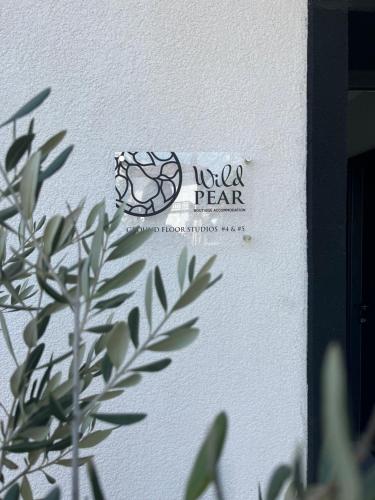 a sign on the side of a wall with a plant at Wild Pear Old Town boutique accommodation in Ohrid