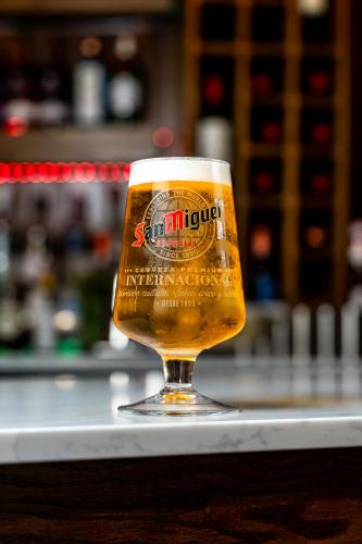 a glass of beer sitting on top of a counter at Trafford Hall Hotel Manchester, Trademark Collection by Wyndham in Manchester