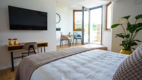 Schlafzimmer mit einem Bett, einem Schreibtisch und einem TV in der Unterkunft Maravida Vacation Rooms in Dobrovo