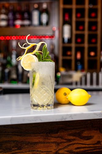 a glass of lemonade sitting on a counter with lemons at Trafford Hall Hotel Manchester, Trademark Collection by Wyndham in Manchester