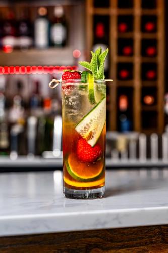 a drink on a counter with a strawberry and lime at Trafford Hall Hotel Manchester, Trademark Collection by Wyndham in Manchester