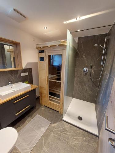 a bathroom with a shower and a sink at Haus Kurparkblick Ferienwohnung Lautersee in Mittenwald
