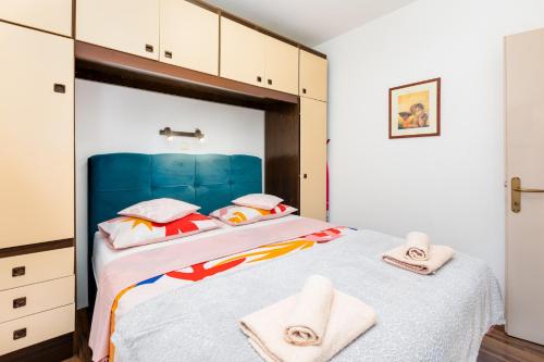 a bedroom with a large bed with towels on it at Apartman Kovač in Malinska