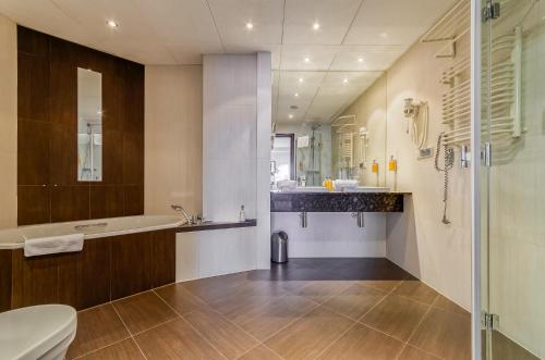 a bathroom with a tub and a sink and a toilet at Hotel Swing in Kraków
