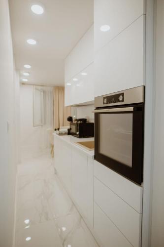 a kitchen with white cabinets and a stove at Apartman 007 in Vukovar