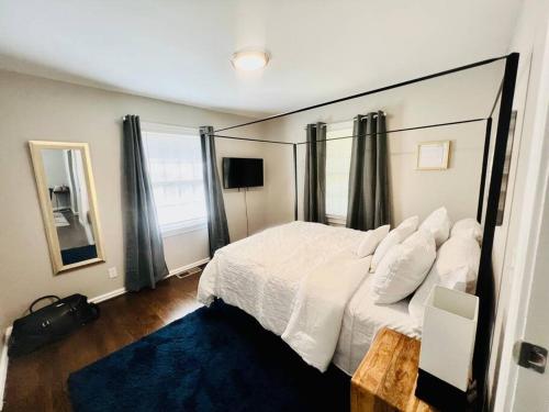 Un dormitorio con una gran cama blanca y una alfombra azul en Peaceful Bungalow Mins to Airport en Birmingham