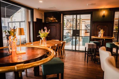 a restaurant with a wooden table and chairs at City Hotel de Jonge in Assen