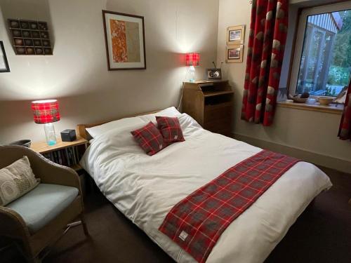 - une chambre avec un lit, une couverture et une chaise dans l'établissement One bed cosy Highland cottage near Beauly, à Beauly