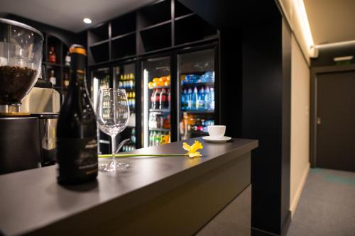 a bar with two glasses and a bottle of wine at Hotel Epic Centrum in Cisnădie