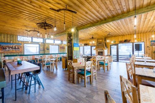 ラシュノフにあるMaggie's Ranchの木製の壁とテーブルと椅子が備わるレストラン