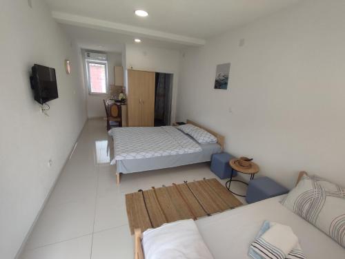 een kleine kamer met 2 bedden en een bank bij Apartments Three Ohrid in Ohrid