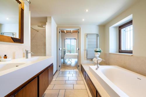 a bathroom with two sinks and a bath tub at La Dimora del Castelluccio in Castiglione di Sicilia