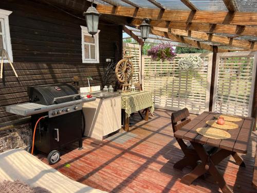 a patio with a grill and a table and a tableablish at Vila Arjola in Kaltanėnai