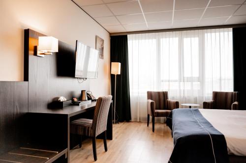 a hotel room with a bed and a desk and chairs at City Hotel de Jonge in Assen