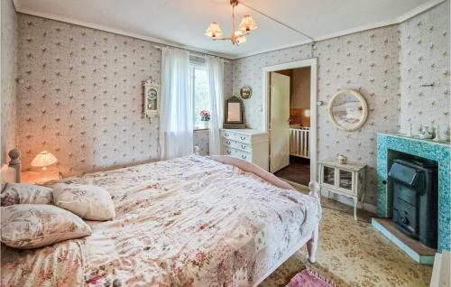 een slaapkamer met een groot bed en een open haard bij 2 Bedroom Stunning Home In Magdegrde 