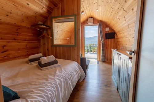 a bedroom with a bed in a wooden house at The Highland Bothies Glamping in Ullapool