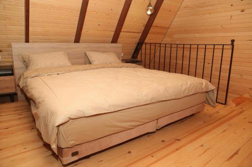 Private Bungalow في طرابزون: سرير كبير في غرفة مع أرضية خشبية