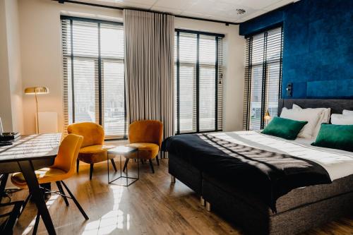a bedroom with a bed and a table and chairs at City Hotel de Jonge in Assen