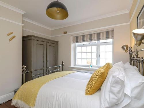 a bedroom with a large white bed with yellow pillows at CASTLE COTTAGE 2 in Richmond
