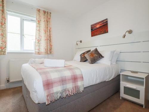 um quarto com uma cama e uma janela em Far Horizons em Newquay