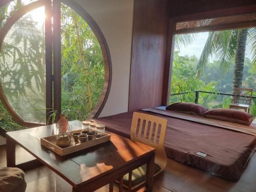 a room with a bed and a table and a window at InnerZen Riverside homestay Ben Tre - Japanese style in Ấp Phú Hòa (3)